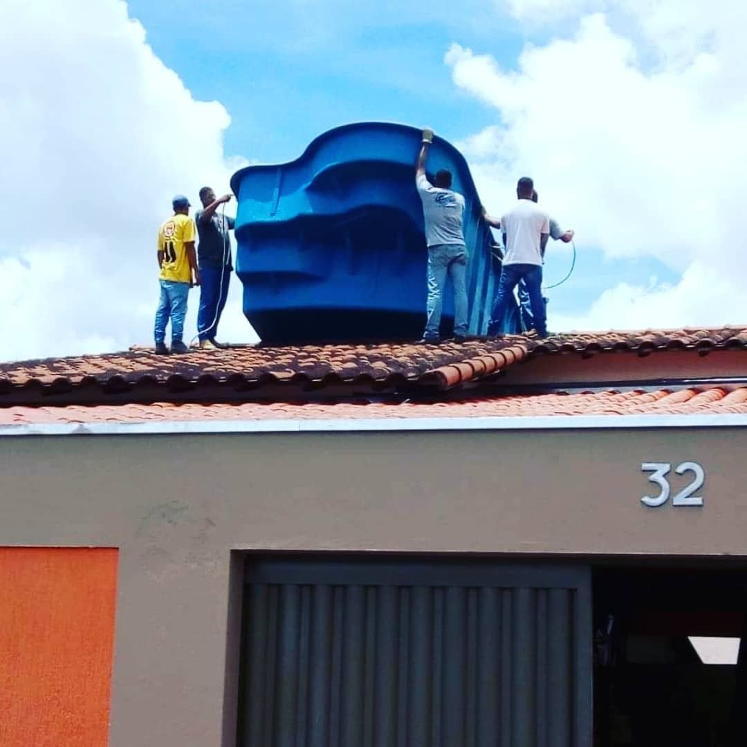 Piscina de fibra sendo içada por cima do telhado